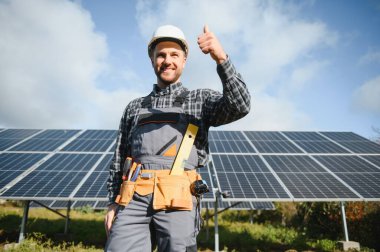 Güneşli bir günde üniformalı ve güneş pilli bir erkek işçi.