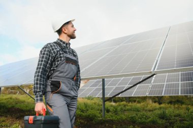 Güneş enerjisi santrali işçisi panellerin durumunu kontrol ediyor.
