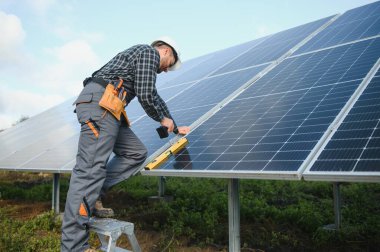 Dışarıda güneş panelleri kuran işçiler.