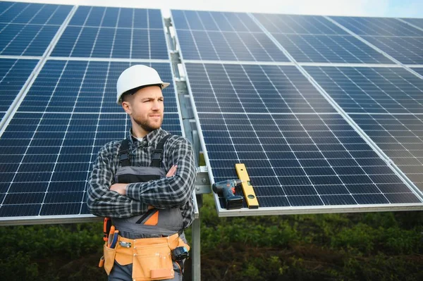 Professional worker installing solar panels on the metal construction, using different equipment, wearing helmet. Innovative solution for energy solving. Use renewable resources. Green energy