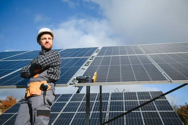 stock image Professional worker installing solar panels on the metal construction, using different equipment, wearing helmet. Innovative solution for energy solving. Use renewable resources. Green energy