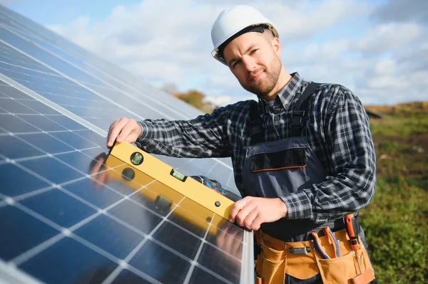 stock image Male worker in uniform outdoors with solar batteries at sunny day