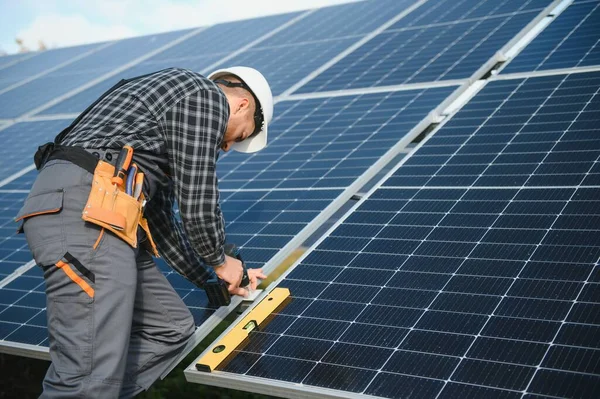 Metal yapıya güneş panelleri yerleştiren profesyonel işçiler, farklı ekipmanlar kullanıyorlar, kask takıyorlar. Enerji çözümü için yenilikçi bir çözüm. Yenilenebilir kaynakları kullan. Yeşil enerji