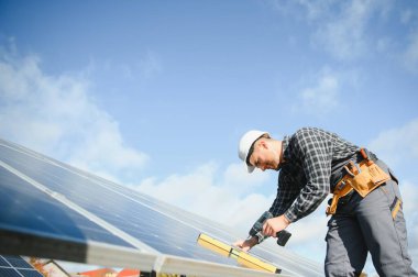 Erkek teknisyenler fotovoltaik güneş modülleri kuruyor. Alternatif ve yenilenebilir enerji kavramı