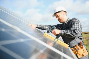 Dışarıda güneş panelleri kuran işçiler.