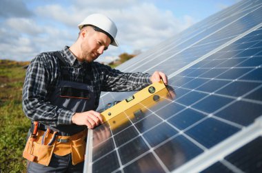 Dışarıda güneş panelleri kuran işçiler.