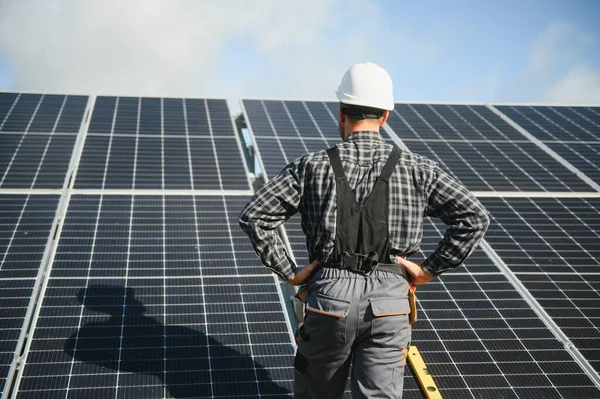 Mężczyzna Pracownik Mundurze Zewnątrz Bateriami Słonecznymi Słoneczny Dzień — Zdjęcie stockowe
