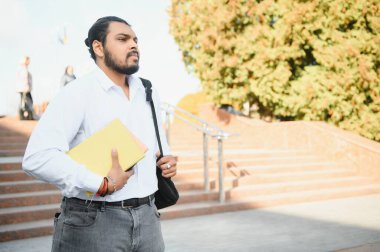 Üniversitedeki mutlu Hintli erkek öğrenci