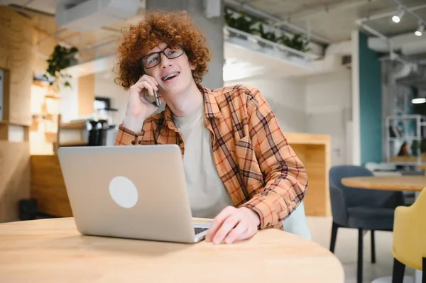 stock image Skilled male programmer wear spectacles for eyes protection while working on freelance via laptop computer,clever student watching tutorial on netbook satisfied e learning courses in cafeteria.