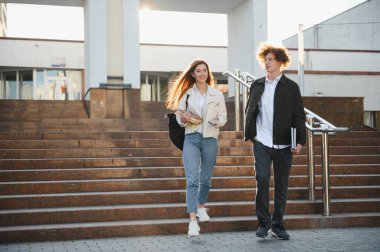 Eğitim, kampüs, arkadaşlık ve insan konsepti. Bir grup mutlu öğrenci dışarıda..