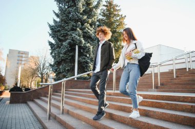 Eğitim, kampüs, arkadaşlık ve insan konsepti. Bir grup mutlu öğrenci dışarıda..