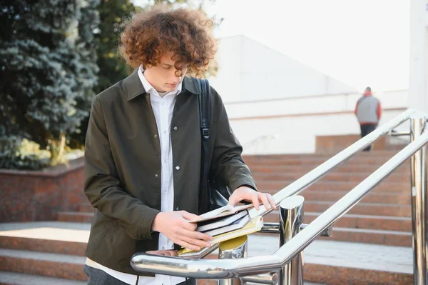 University Smiling 年轻学生男子手持一本书和一袋上大学背景 年轻的笑脸学生户外生活方式 City Student — 图库照片