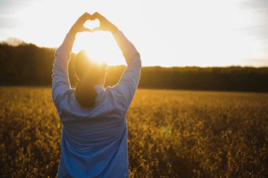 Beyaz kadın çiftlik işçisi yaz akşamı Ukrayna 'da bir yerlerde soya tarlasını denetliyor..