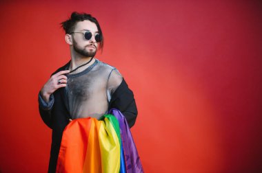 LGBTQ topluluğunun gökkuşağı bayrağı tutan mutlu bir gay..