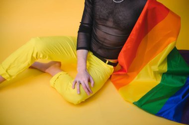 Beyaz arka planda LGBT Rainbow bayrağı taşıyan gururlu, yakışıklı genç bir adam. Eşcinsel gurur bayrağı taşıyan adam