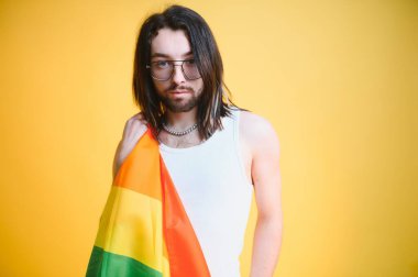 LGBTQ topluluğunun gökkuşağı bayrağı tutan mutlu bir gay..