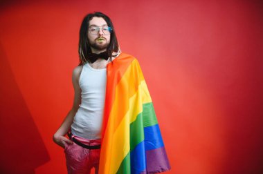 LGBTQ topluluğunun gökkuşağı bayrağı tutan mutlu bir gay..