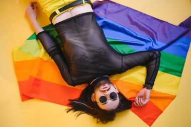 Eşcinsel adam renkli arka plan stüdyo resminde izole edilmiş gökkuşağı çizgili bayrak tutuyor. Insanlar yaşam tarzı lgbtq konsepti.