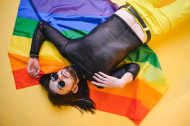 LGBTQ topluluğunun gökkuşağı bayrağı tutan mutlu bir gay..