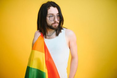 LGBTQ topluluğunun gökkuşağı bayrağı tutan mutlu bir gay..