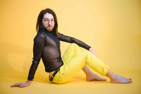 stock image Young gay man is standing in the studio and posing for a camera