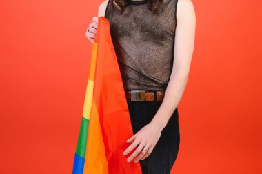 Eşcinsel adam renkli arka plan stüdyo resminde izole edilmiş gökkuşağı çizgili bayrak tutuyor. Insanlar yaşam tarzı lgbtq konsepti.