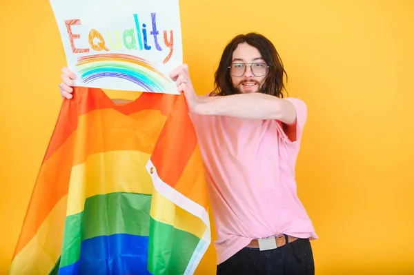 stock image Handsome young man with pride movement LGBT Rainbow flag on shoulder against white background. Man with a gay pride flag