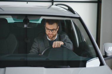 Onun gerçek aşkı. Yepyeni bir arabada mutlu bir şekilde oturan olgun bir adamın portresi..