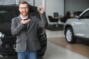 Galeride arabanın yanında duran takım elbiseli yakışıklı bir satıcının portresi..