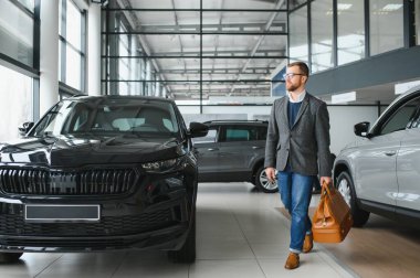 Yetişkin müşteri erkek müşteri alıcısı klasik takım elbise giyiyor. Beyaz gömlek, araba almak istiyor. Sergi salonunun galerisindeki araba galerisindeki araba galerisinde yeni bir araba almak istiyor. Satış konsepti