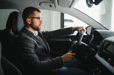 Arabadaki yakışıklı erkek taksi şoförü.