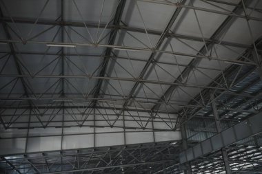 İnşaat için çelik çatı yapısı. İnşaat halindeki bir binanın metal çatı yapısı mavi gökyüzü arka planında beyaz bulutlu.