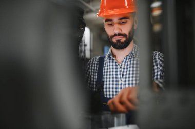 Mutlu Profesyonel Ağır Sanayi Mühendisi Üniforma Giyen İşçi ve Çelik Fabrikasındaki Sert Şapka. Gülümseyen Endüstri Uzmanı Metal İnşaat Üretiminde Duruyor.