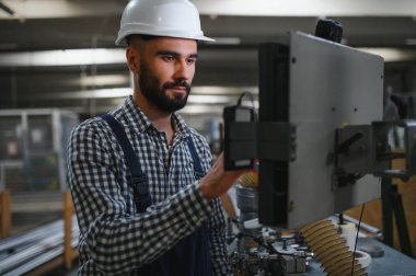 Mutlu Profesyonel Ağır Sanayi Mühendisi Üniforma Giyen İşçi ve Çelik Fabrikasındaki Sert Şapka. Gülümseyen Endüstri Uzmanı Metal İnşaat Üretiminde Duruyor.