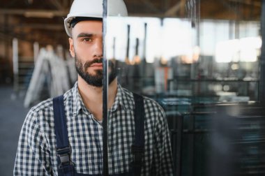 Camcı cam fabrikasında cam taşır.