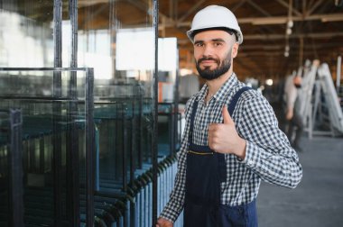 Camcı cam fabrikasında cam taşır.