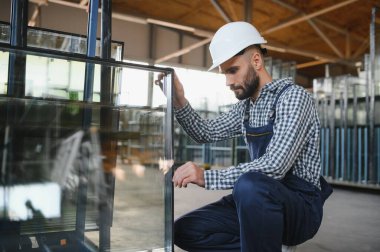 Camcı cam fabrikasında cam taşır.