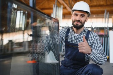 Camcı masadan bir ayna parçası alıyor. Cam fabrikası, üretim..