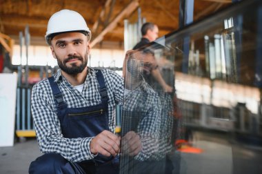 Camcı cam fabrikasında cam taşır.
