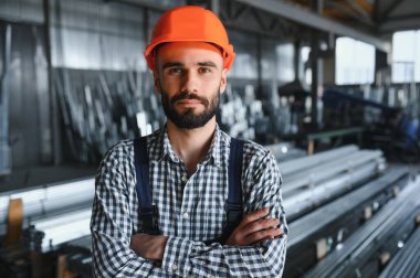 Mutlu Profesyonel Ağır Sanayi Mühendisi Üniforma Giyen İşçi ve Çelik Fabrikasındaki Sert Şapka. Gülümseyen Endüstri Uzmanı Metal İnşaat Üretiminde Duruyor.