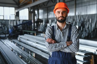 Fabrika işçisinin portresi üretim salonundaki koruyucu ekipmanlarda.