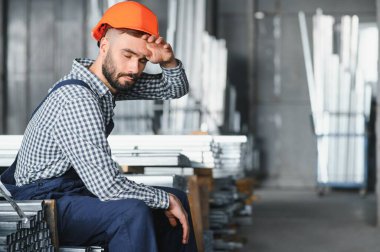 Adam fabrikada inşaat için metal profili seçti.