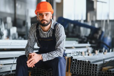Mutlu Profesyonel Ağır Sanayi Mühendisi Üniforma Giyen İşçi ve Çelik Fabrikasındaki Sert Şapka. Gülümseyen Endüstri Uzmanı Metal İnşaat Üretiminde Duruyor.
