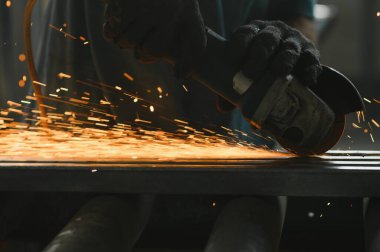 İşçi kesme metal taşlama ile yakın çekim. Demir taşlama sırasında yol açtı. Düşük odak derinliği.