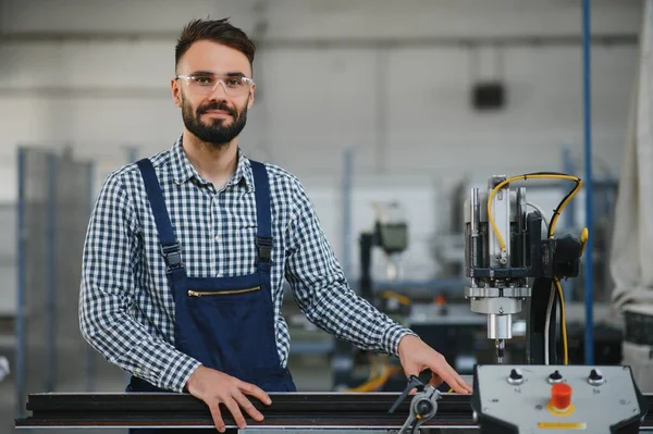 stock image Worker in uniform working on machine in PVC shop indoor.