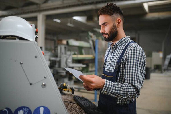 modern industrial machine operator working in factory.