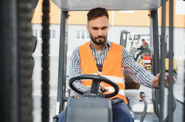 Depoda çalışan ve forklift kullanan bir adam..