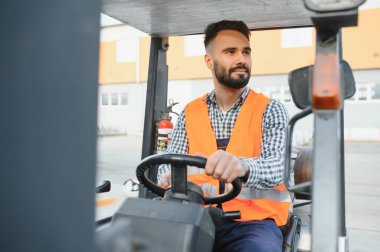 Forklift kullanırken bir nakliye şirketinin deposunda forklift sürüyordu..