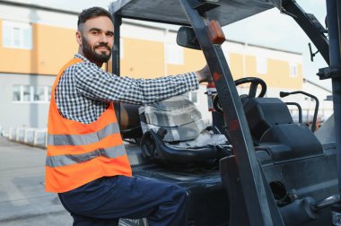 Depoda çalışan ve forklift kullanan bir adam..