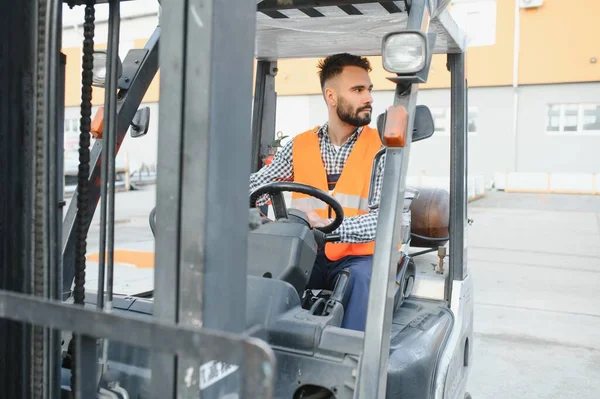 stock image Waving forklift driver in the warehouse of a haulage company while driving forklift.